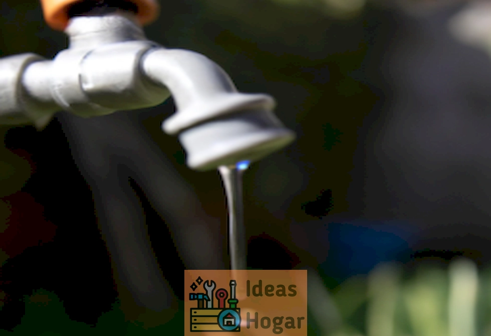 Imagen de un grifo goteando agua en un jardín, ilustrando una fuga de agua en exteriores y la necesidad de detectar y reparar el problema.