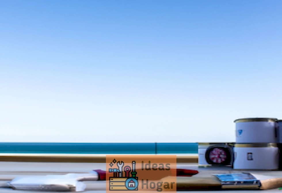 Imagen ilustrativa de un deck recién pintado con vista al mar, con brochas y latas de pintura, representando el tema del costo promedio de pintar un deck en el año 2024.